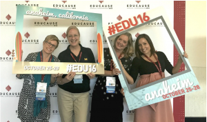 Four women at Educause 2016, holding photo frames and standing in front of conference backdrop.