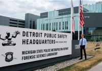 Reid Wilson standing outdoors in front of sign: Detroit Public Safety HQ