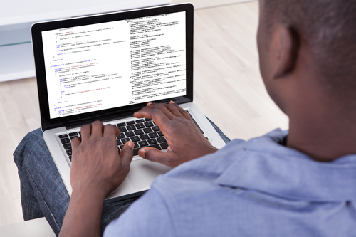 Close-up Of person programming on a laptop