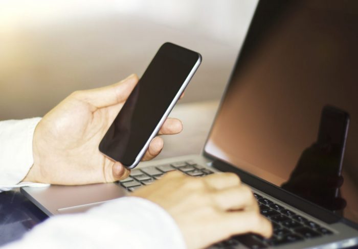 businessman typing on a cellphone, close up