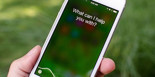 photo of hand holding iPhone with text on screen: What can I help you with?