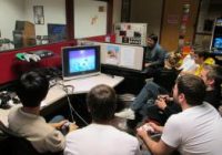 Bunch of guys sitting around playing video games.