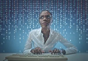 African American woman at computer, data stream overlay.