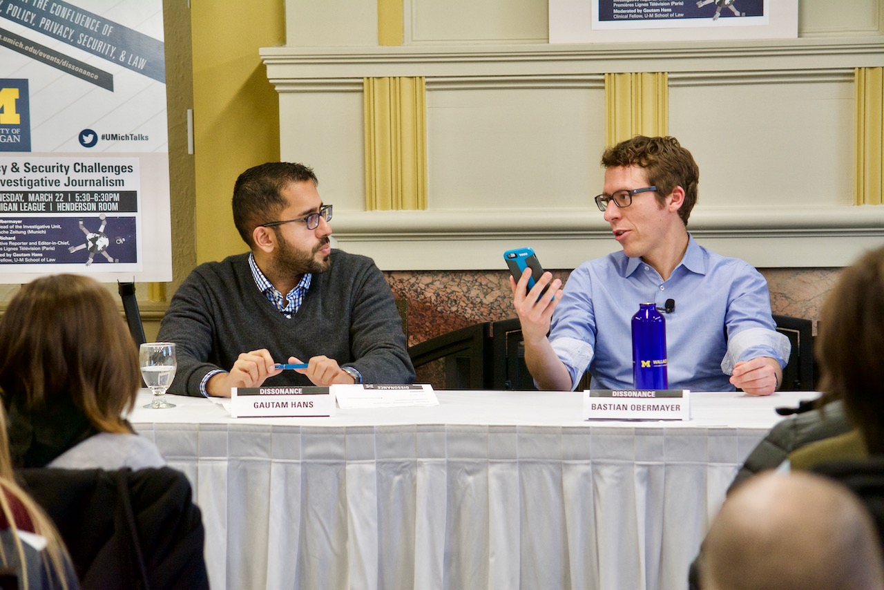 Panelist Bastian Obermayer holds up his mobile phone to make a point