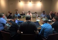 Team members of IIA, Network Operations, Network Security Operations, and Network Engineering, gather around a table to talk through potential attack scenarios