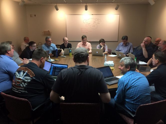 Team members of IIA, Network Operations, Network Security Operations, and Network Engineering, gather around a table to talk through potential attack scenarios