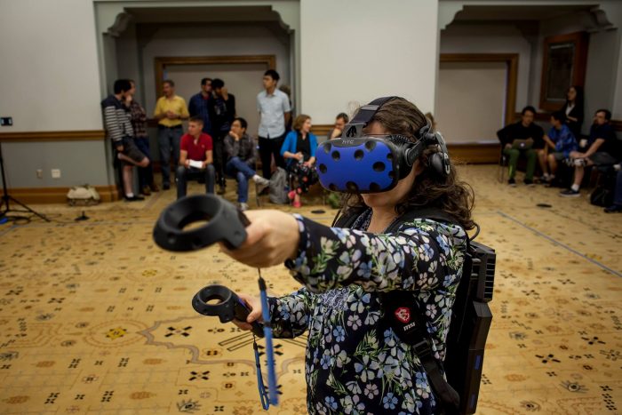 A woman demonstrates the HTC Vive virtual reality headset at the School of Information