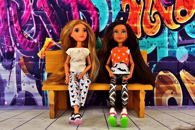 two dolls sitting on a bench