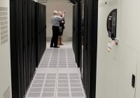 two people looking at bank of servers