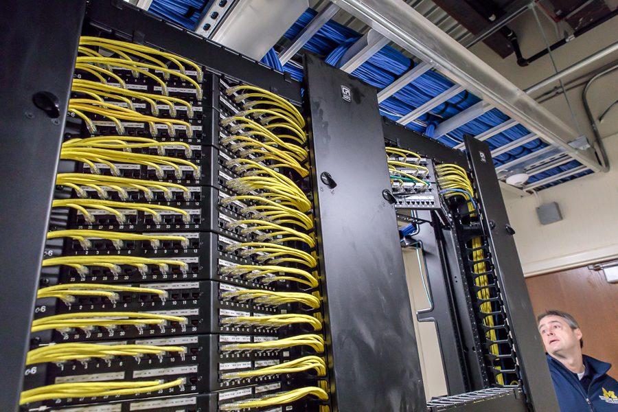 A rack of networked machines are pictured in a communications closet