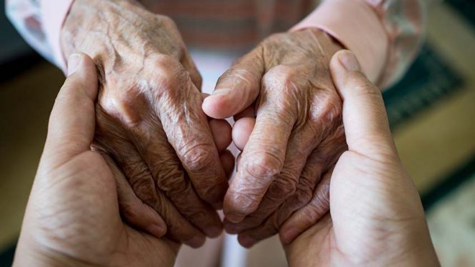 Holding hands with an elderly adult