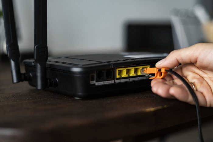 hand plugging in cable to router