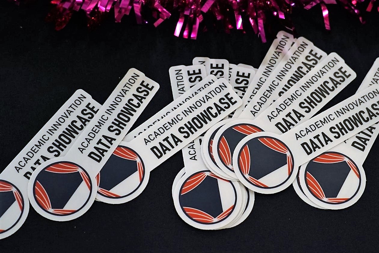 bunch of AI Data Showcase stickers on a table