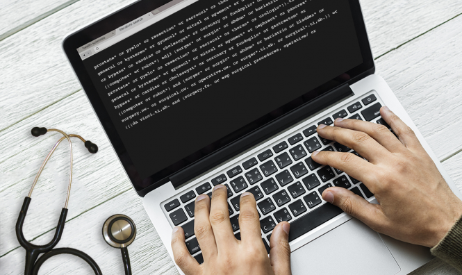 hands on laptop, next to stethoscope