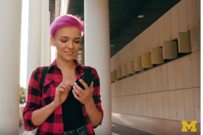 young woman with pink hair using her phone