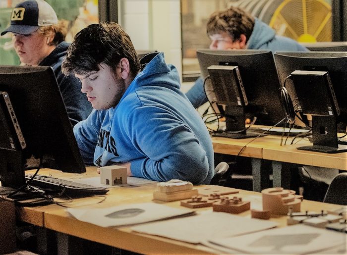 young man in blue sweatshire working at computer