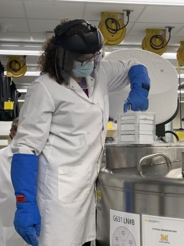 Vici Blanc, Ph.D., director of the U-M Central Biorepository, lifts a rack of blood samples out of the dedicated freezer for COVID-19 samples.