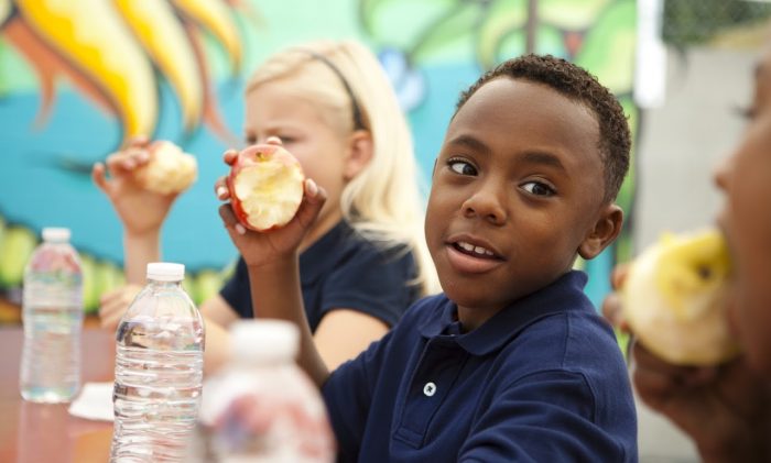 A student enjoys an apple.