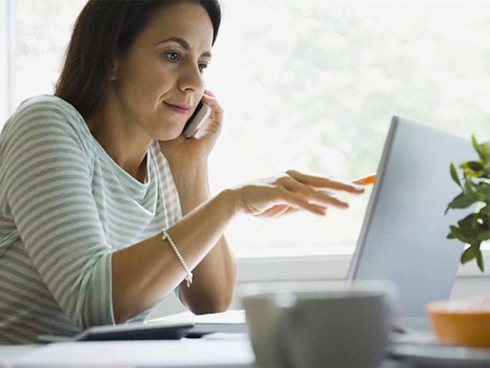 A woman looks at a laptop.