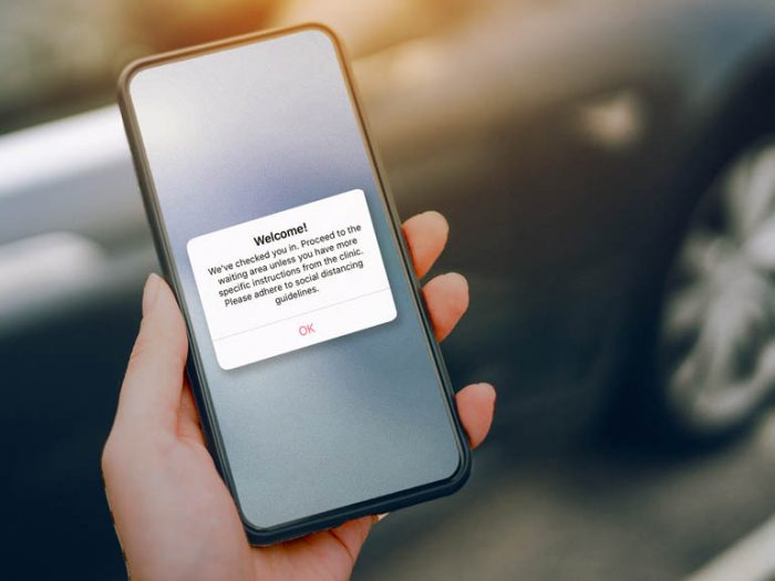 Hand holding mobile phone with welcome screen.