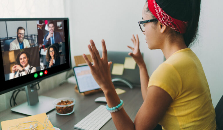 Young woman sitting at computer, videoconferencing with colleagues