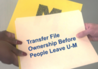 A file folder is handed from one person to another.