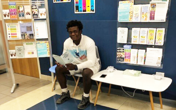 A young person reads a brochure.