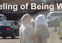 The Feeling of Being Watched - Two women wearing headscarves seen from behind walking across a parking lot.