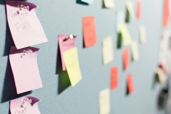 A side angle view of multi-colored sticky notes on a board.