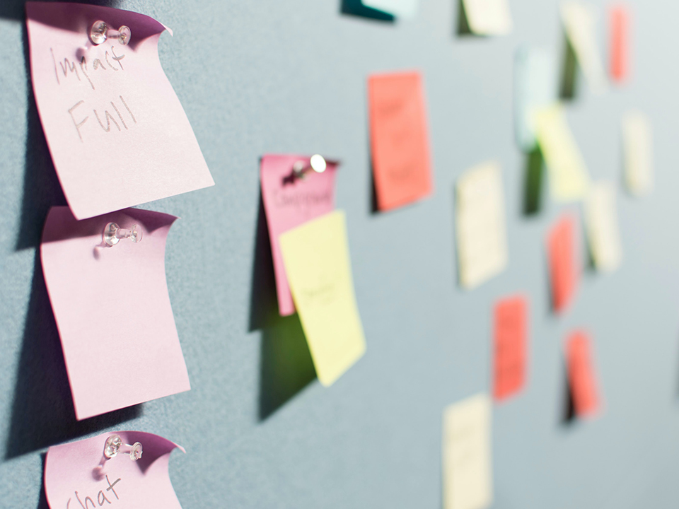 A side angle view of multi-colored sticky notes on a board.