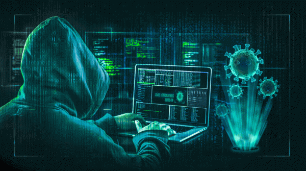Hooded person sitting at a computer with virus icons
