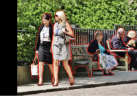 A screenshot of the ImageExplorer app identifies two women walking down a sidewalk in the photo, as well as their bags, two benches, and three more people in the background.