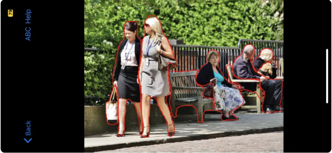 A screenshot of the ImageExplorer app identifies two women walking down a sidewalk in the photo, as well as their bags, two benches, and three more people in the background.