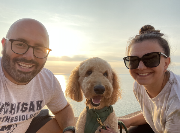 smiling people with their dog in the middle