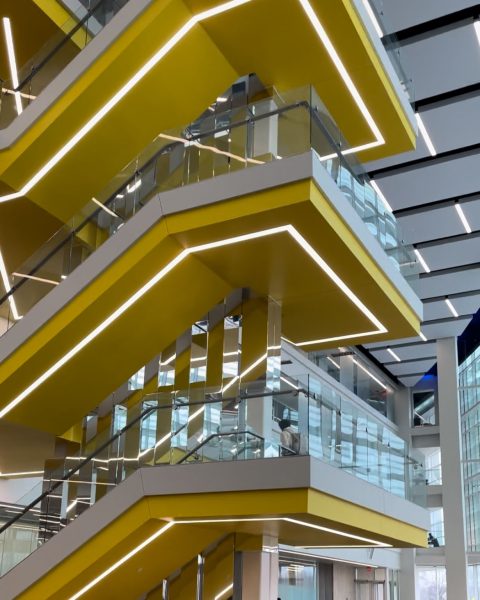 The staircase at the Ford Motor Company Robotics Building. It is yellow with lights following its shape.
