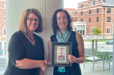 Carrie Shumaker, Dearborn vice chancellor for information technology and chief strategy officer, passes the chair leadership position to vice chair Cathy Curley, chief information officer, College of Literature, Science and the Arts