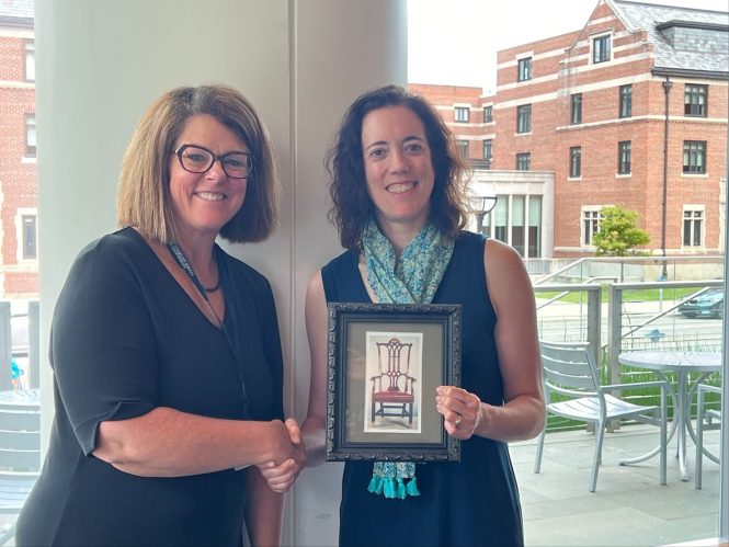 Carrie Shumaker, Dearborn vice chancellor for information technology and chief strategy officer, passes the chair leadership position to vice chair Cathy Curley, chief information officer, College of Literature, Science and the Arts