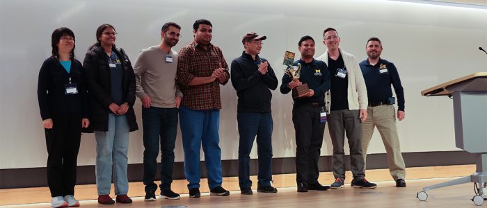 The Hacks With Friends winning team of both the judges' choice and the People's Choice standing on stage with their trophy.