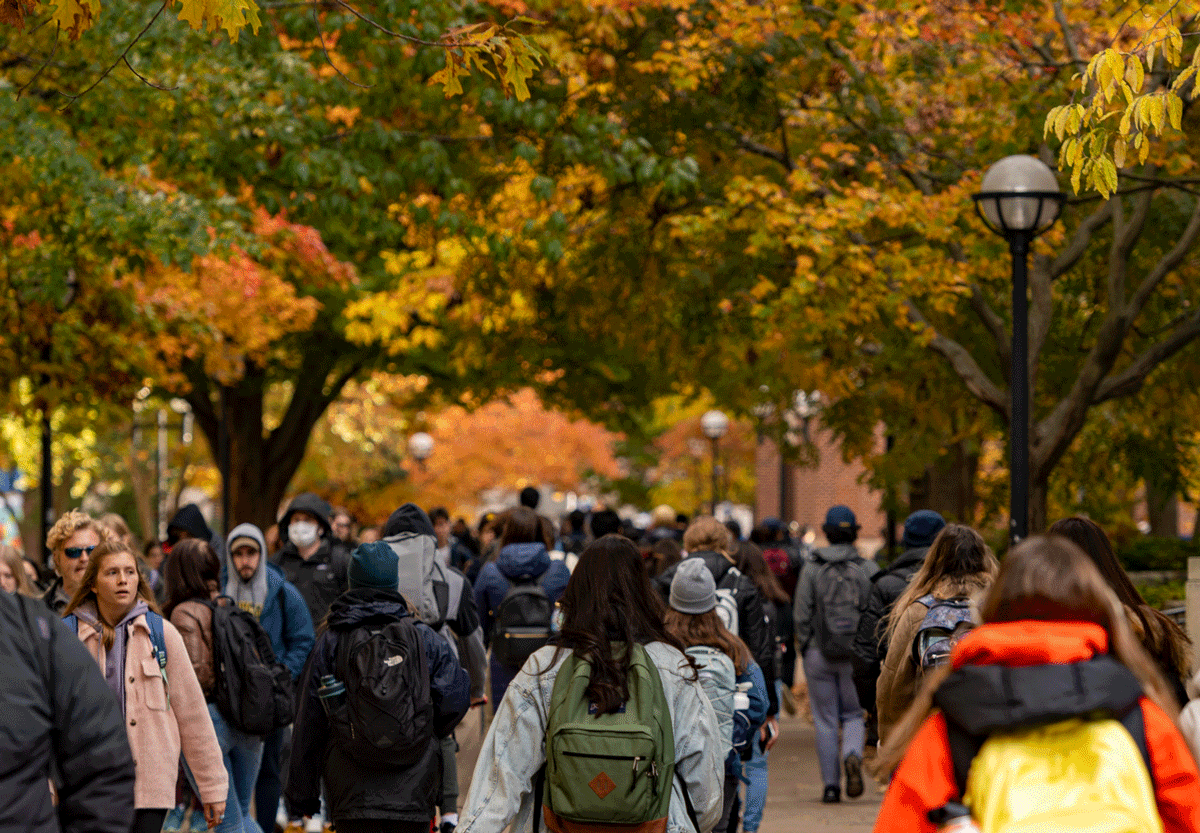 Michigan students walking through the Diag among fall colors