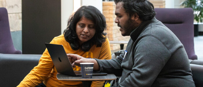 Two members of pitch 10 working on their hack