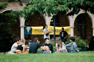 Students in front of a welcome sign on the Diag