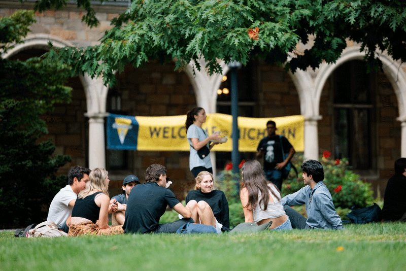Students in front of a welcome sign on the Diag